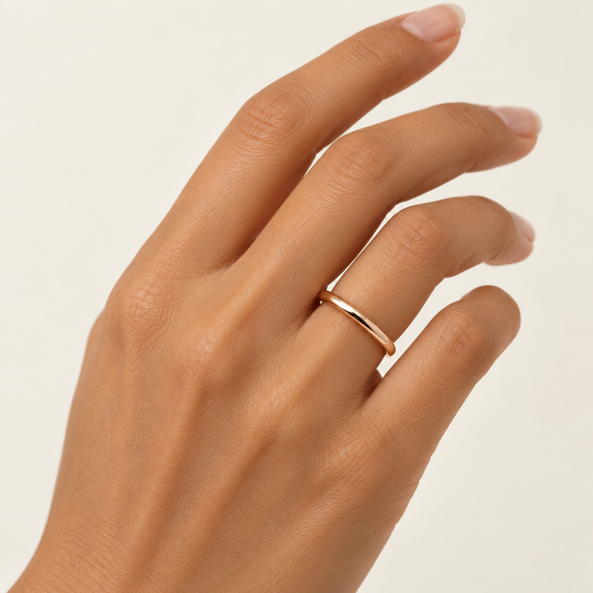 ARCADIA 2 mm — woman wearing an 18K rose gold wedding band, AI model illustration