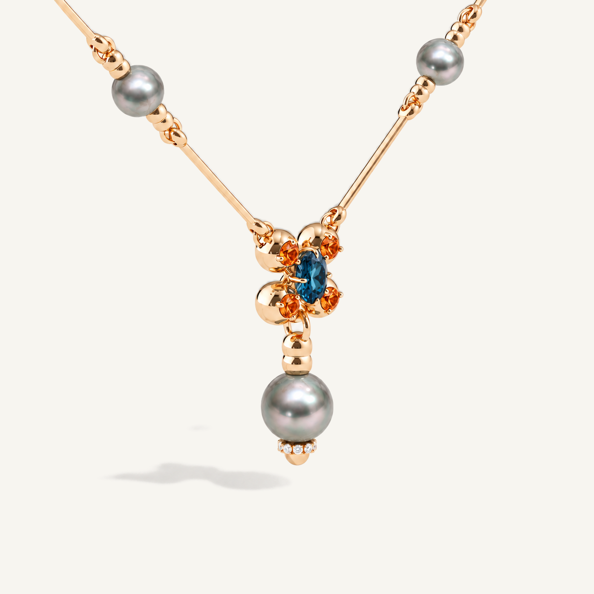 Barbelle necklace with grey Tahitian pearls, London blue topaz and mandarin garnets — angle one