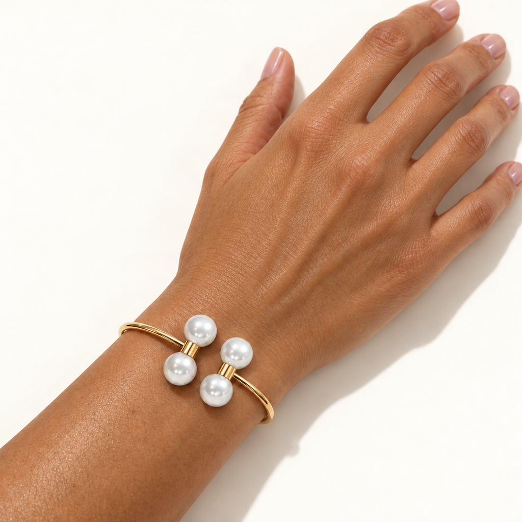 Barbelle Couple Bangle in 18K yellow gold with South Sea pearls, worn on a woman's wrist