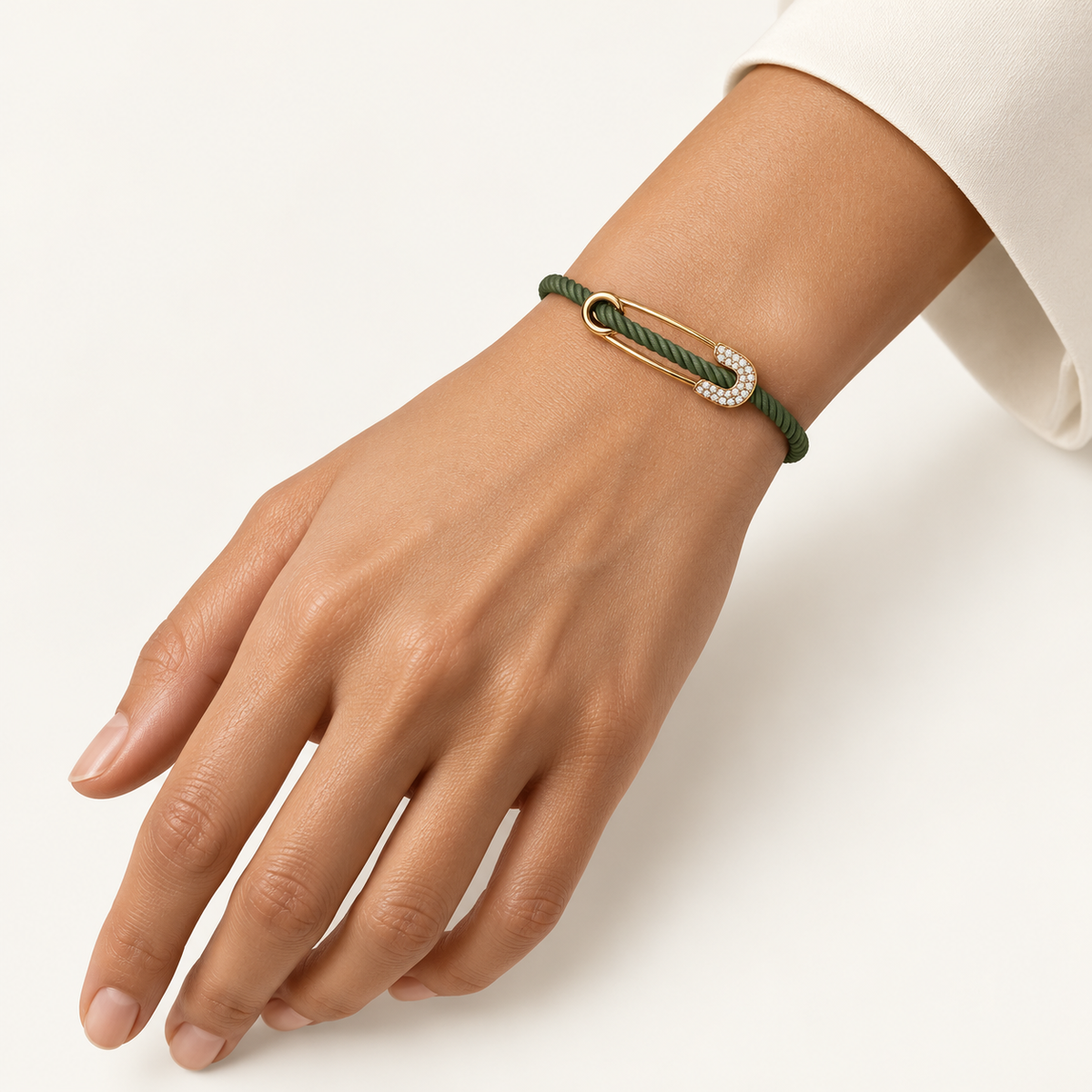 DEEP TEAL Rebel Pin Chord Bracelet — 18K gold with diamond pavé and green cord on a woman's hand with natural nails